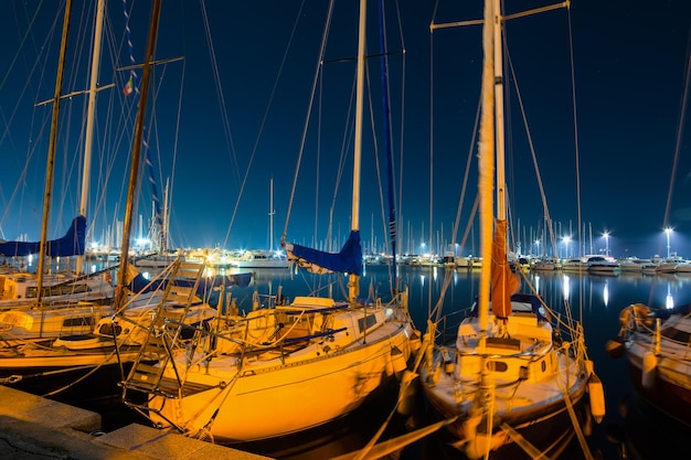 Barcos en el puerto de Alghero en la noche Italia