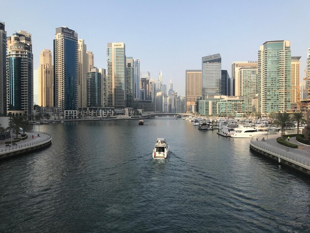 Foto barcos en el río con edificios en el fondo