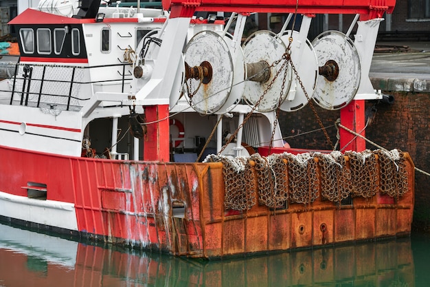 Barcos rojos oxidados y redes metálicas para pescar vieiras