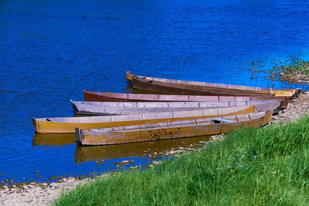 Barcos tradicionais de pesca de madeira com fundo chato na margem do rio, paisagem rural