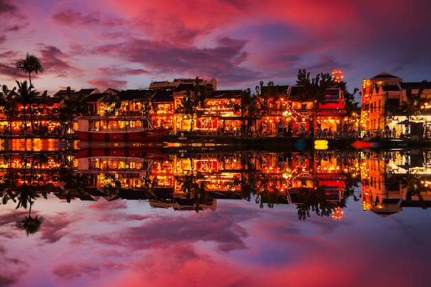 Barcos tradicionais em frente à arquitetura antiga em Hoi An Vietnam