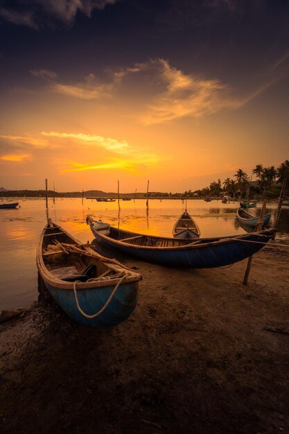 Barcos tradicionais na lagoa de O Loan no pôr-do-sol na província de Phu Yen, Vietnã