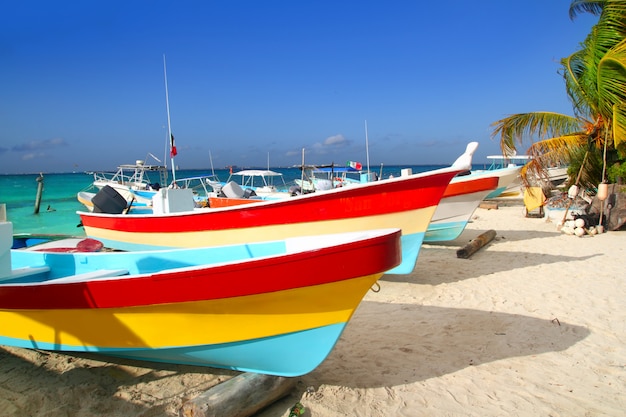 Barcos tropicais coloridos encalhados na areia isla mujeres