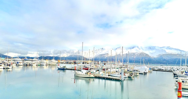 Barcos de vela atracados en el puerto contra el cielo