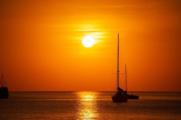 Barcos de vela de yate de silueta o barcos de viaje en el hermoso mar de phuket al atardecer cielo dorado Increíble para el fondo de vacaciones de verano y destino de viaje o sitio web Hermosa isla de phuket