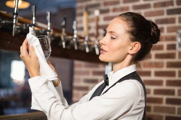 Bardame, die ein Glas säubert