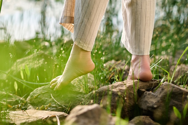 Barfüßige Frau, die auf Steinen im Park steht