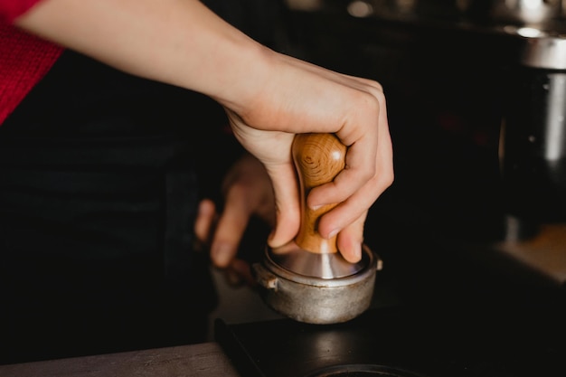 Barista apisonando café con un tamper