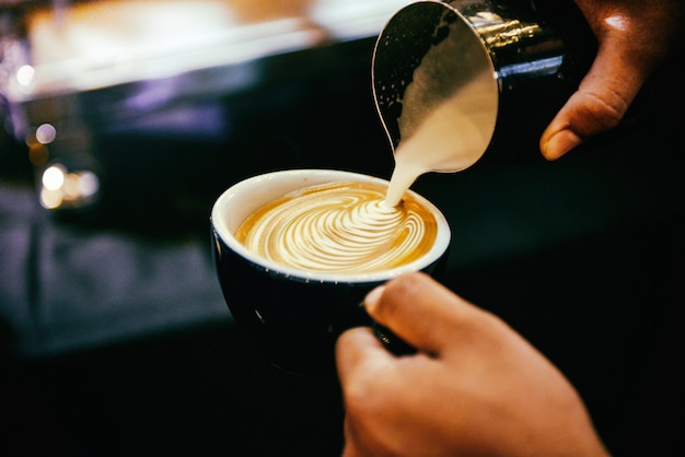 Barista arbeitet in einem Café, Nahaufnahme von Barista drückt gemahlenen Kaffee mit Tamper