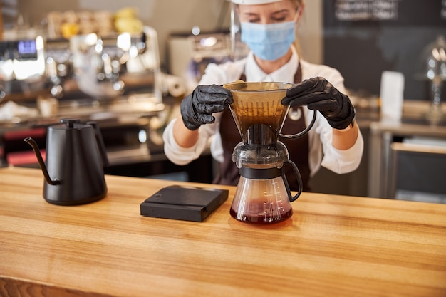 Barista Barista gießt manuellen Tropfbrüher zum Zubereiten von Kaffee