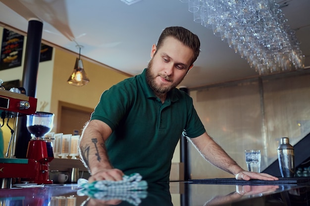 Barista Barkeeper wäscht die Oberfläche der Bar. Reinigung in einem Café-Restaurant.