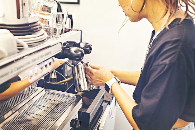 Barista bereitet Kaffee an der Kaffeemaschine zu Café-Theke