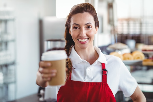 Barista bonita dando taça take-away