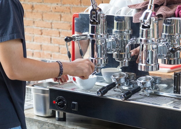 Barista brauen heißen Kaffee mit Kaffeemaschine