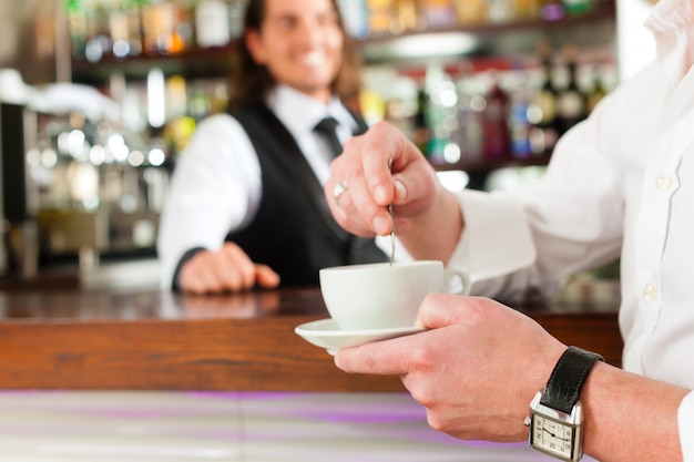 Barista com cliente em seu café ou coffeeshop