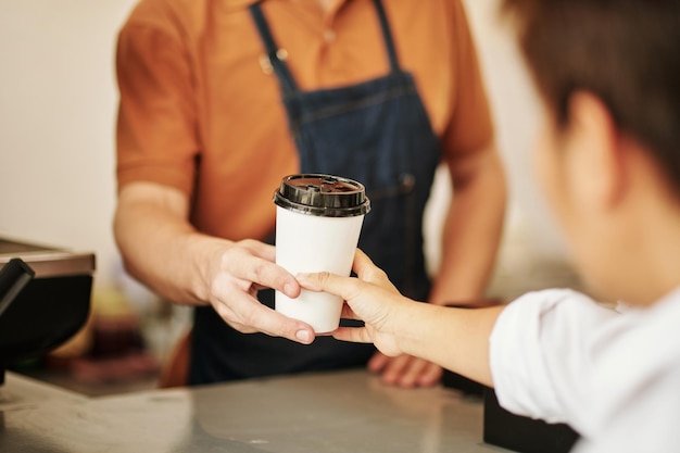 Barista dando taza de café al cliente