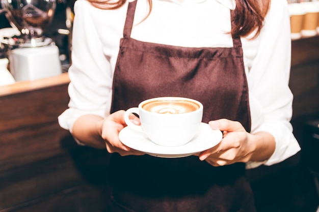 Barista, das Kaffee Lattekunst in der Kaffeestube hält