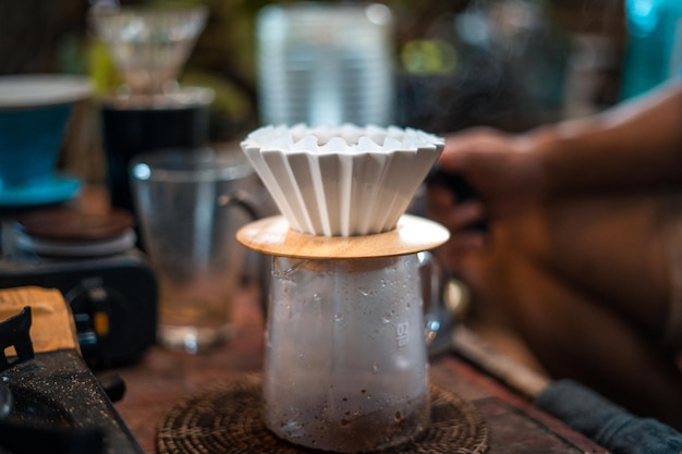 Barista de café de gotejamento derramando água no café moído com filtro