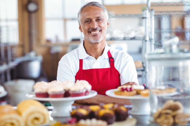 Barista, der an der Kamera hinter Zähler lächelt