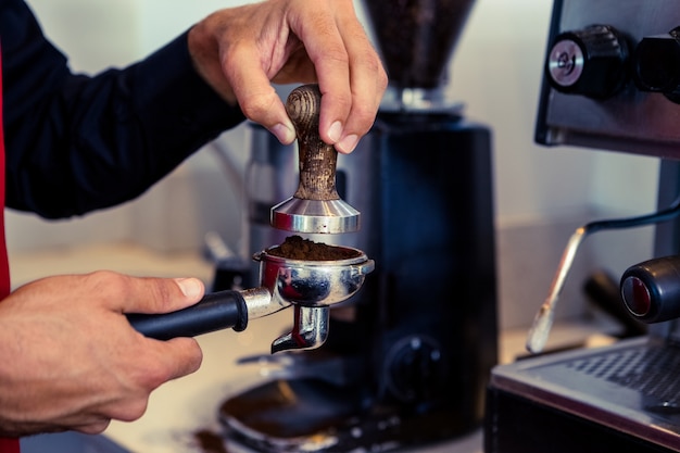 Barista, der frischen Kaffeesatz drückt