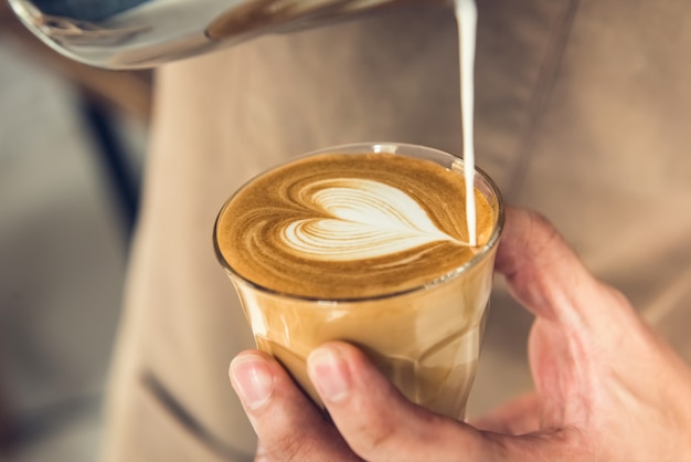 Barista, der Herzform latte Kunstkaffee macht