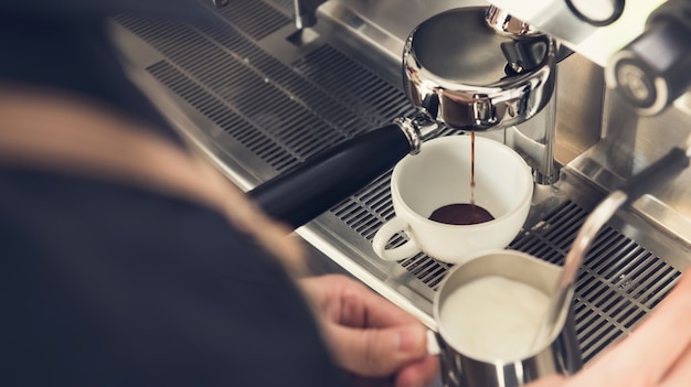 Barista, der Kaffee mit Maschine am Café macht