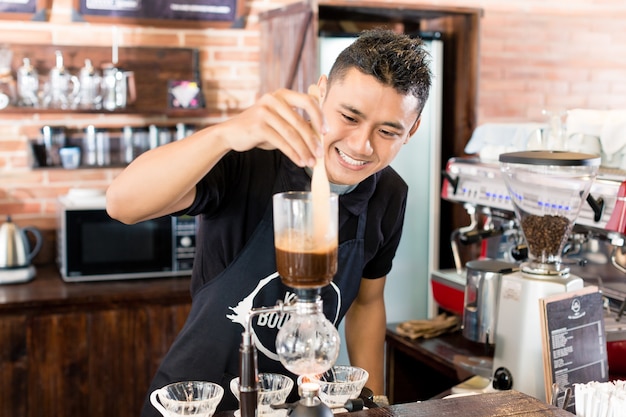 Barista, der tropfenfängerkaffee in der asiatischen kaffeestube zubereitet