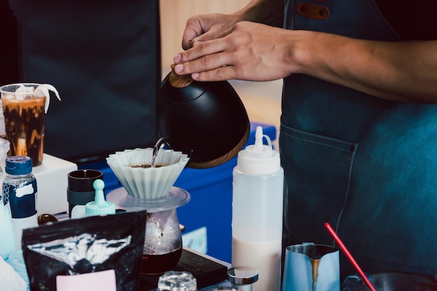 Barista derramando água quente para fazer café coado