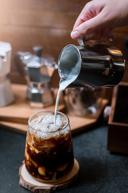 Barista derramando leite em vidro