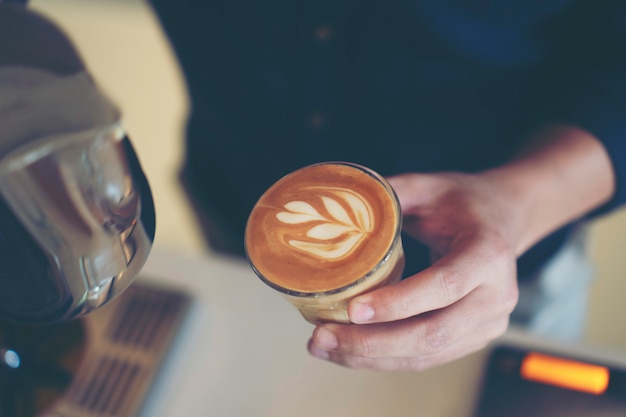 Barista está vertiendo arte con leche.