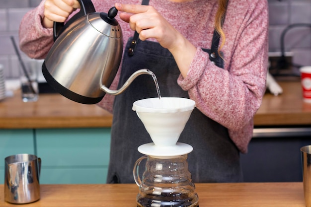 Foto barista faz café expresso usando um funil. o processo de fazer café no provador