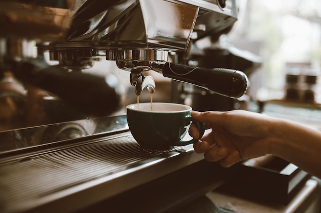 Barista fazendo café com máquina profissional Café derramando em uma xícara pequena empresa startup