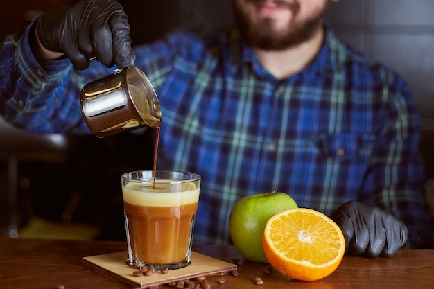 Foto barista fazendo coquetel de café. espresso com suco de laranja e maçã