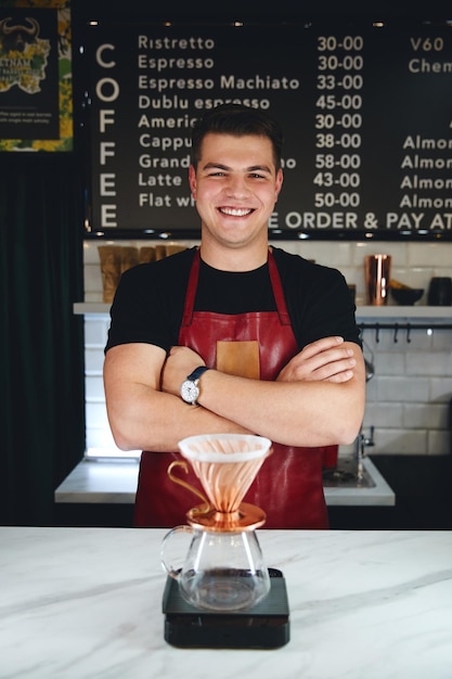 Barista fazendo um gotejamento de café, derramando água quente da chaleira sobre o café