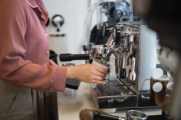Barista femenina haciendo café en una máquina de café