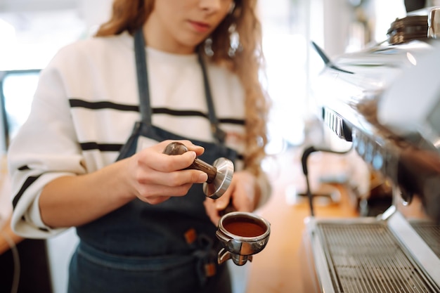 Barista feminina fazendo café em uma máquina de café Conceição de negócios e serviço Alimentos para levar