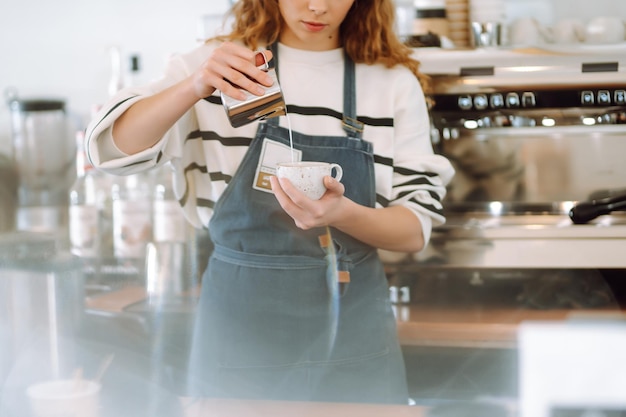 Barista feminina fazendo café em uma máquina de café Concepção de negócios e serviços Comida para viagem