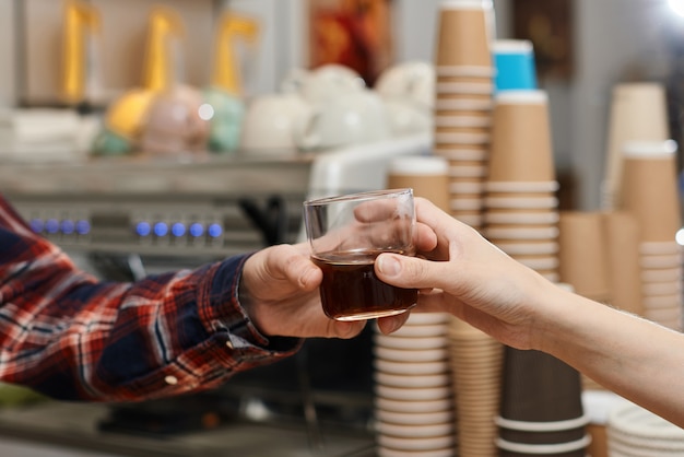 Barista gibt dem Kunden ein Glas frischen Kaffee