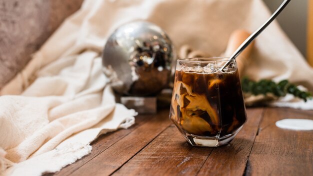 Barista gießt Milch in ein Glas Eiskaffee