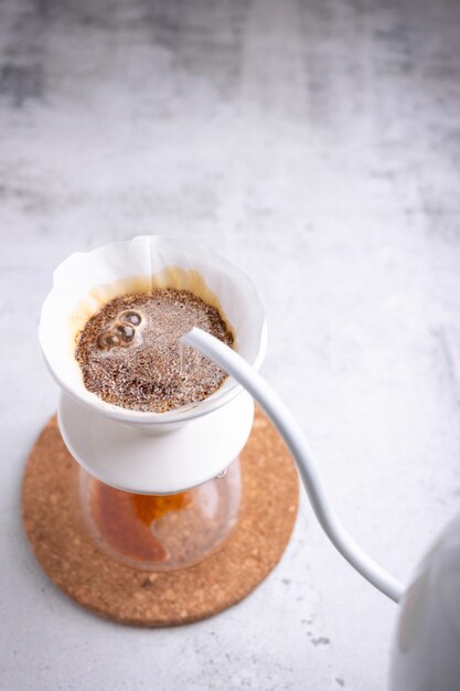 Barista goss heißes Wasser über den gemahlenen Kaffee.