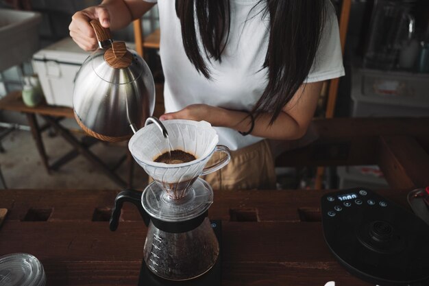 Foto barista goteando café y café lento estilo barra de madera