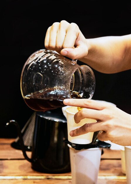 Foto barista haciendo café barista vertiendo café goteante en el vaso