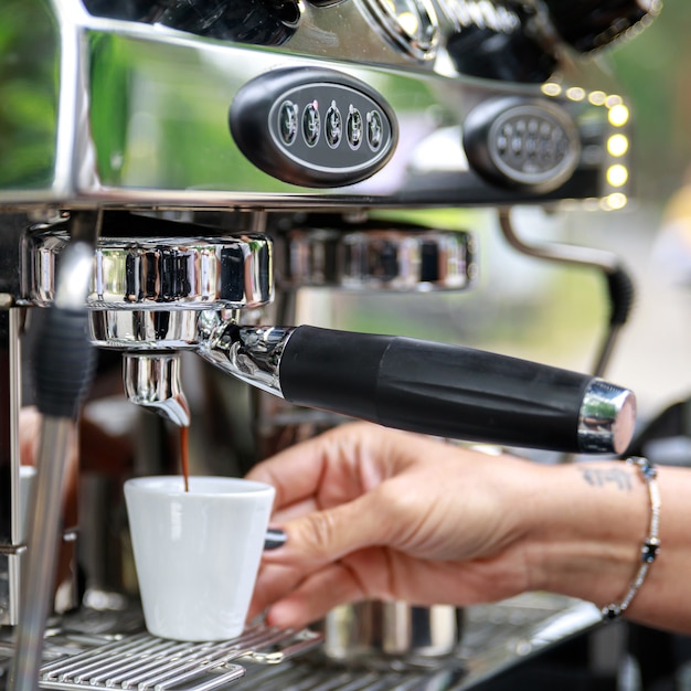 Barista haciendo café con máquina de espresso profesional. Trabaja en detalles.