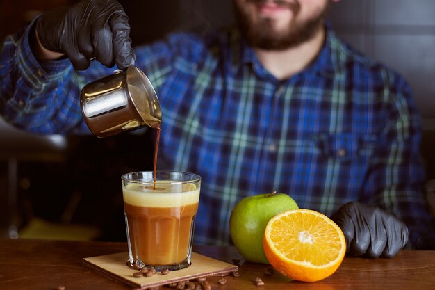 Foto barista haciendo cóctel de café. espresso con jugo de naranja y manzana