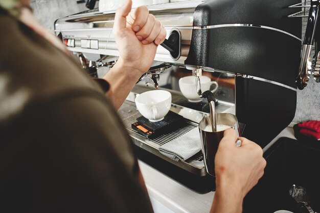 Barista. Hand, die die Kaffeenahaufnahme macht