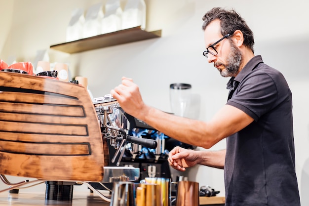 Barista homem trabalhando na cafeteria.