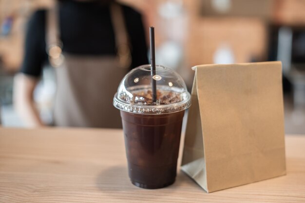 Barista in Schürze und Gesichtsmaske hinter der Theke, bereit zum Kaffeeservice