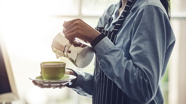 Barista macht Espresso, Americano, Cappuccino, Latte, Mokka und bereitet Kaffeegetränk vor.