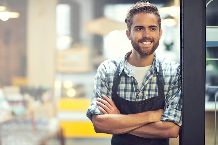 Foto barista mann oder lächeln an der tür des cafés für den kundendienst willkommen oder gastfreundschaft mit gekreuzten armen kleinunternehmen manager kellner oder denken im café eingang für den start des tages oder reflexion