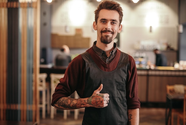 Barista masculino de pie en el café